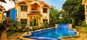 a house with a swimming pool in front of a house at Asif 3 bedroom luxury villa with swimming pool and kitchen in Nagoa-Bardez