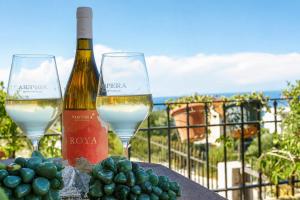 two glasses of white wine and grapes on a table at Breeze in Koumeika