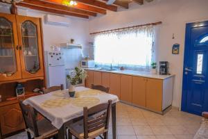 a kitchen with a table and a kitchen with a blue door at Breeze in Koumeika +11 photos