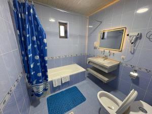 a blue bathroom with a toilet and a sink at Porso Boutique Hotel in Bukhara