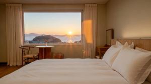 a bedroom with a large bed and a large window at Namhae U9Stay in Namhae +2 photos