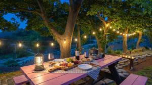 a picnic table with a plate of food and lights at Namhae U9Stay in Namhae
