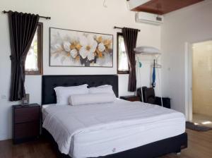 a bedroom with a large bed with white sheets at Himalaya 2 - Private Triangle in Bandung