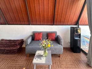 a living room with a couch and a table with flowers at Himalaya 2 - Private Triangle in Bandung