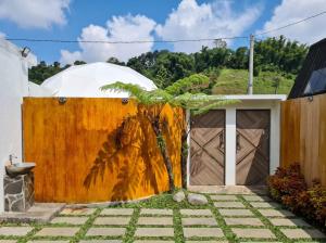 a house with a wooden fence and a palm tree at Himalaya 2 - Private Triangle in Bandung +2 photos