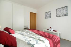 a bedroom with a bed with a red and white blanket at Lavanda Dream Apartment in Split