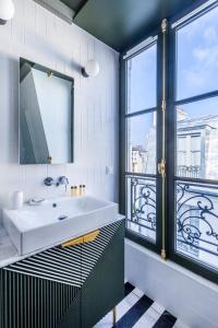 a bathroom with a sink and a large window at Bob Hotel in Paris