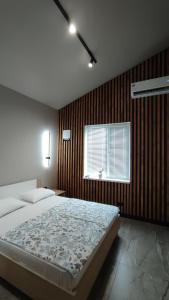 a bedroom with a large bed and a window at Villa MegaLit - відпочинок у котеджах з чанами біля Косино та Берегово in Velyka Bihanʼ