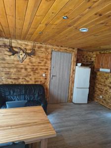 a living room with a couch and a refrigerator at Osada leśna in Sztabin