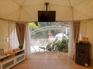 a room with a large window with a tv on top at Himalaya 1 - Private Dome in Panjadakan