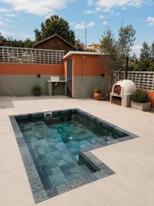 a swimming pool on a patio with a house at Estia Mylona in Ayios Therapon +2 photos
