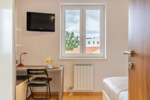 a bedroom with a desk and a window and a chair at Sunny Day self check in in Rijeka