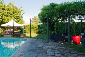 a swimming pool with a table and chairs and an umbrella at Villla DUO in Besançon