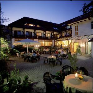 فندق 3 كونيغي في Oberwolfach: فناء في الهواء الطلق مع طاولات وكراسي ومبنى