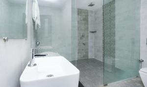 a bathroom with a sink and a glass shower at Hotel Sunrise Luxury Stays in Chikmagalūr +38 photos