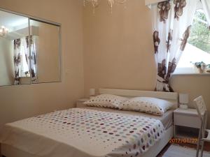 Schlafzimmer mit einem Bett mit einem Spiegel und einem Fenster in der Unterkunft Apartment Villa Bonadea in Slano