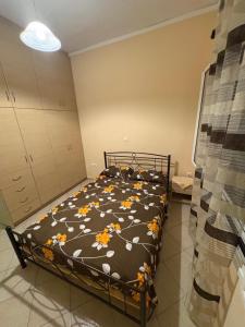 a bedroom with a bed with flowers on it at Διαμερισμα στο Αιγιο in Aigio