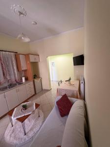 a room with a bed and a table and a kitchen at Διαμερισμα στο Αιγιο in Aigio +1 photo