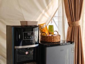 a microwave and a basket on top of a refrigerator at Azalea 1 - Private Dome in Bandung
