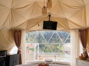 a bedroom with a large tent with a large window at Azalea 1 - Private Dome in Bandung