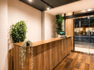 a lobby with a reception desk with plants at Tokyo Guesthouse HIVE in Tokyo