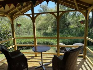 a patio with a table and chairs on a porch at Woody Nook Annexe in Pavenham