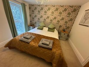 a bedroom with a bed with two towels on it at Woody Nook Annexe in Pavenham
