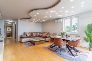 a living room with a couch and a table at Sunny Day self check in in Rijeka +8 photos