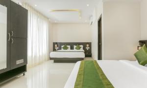 a bedroom with two beds and a television in it at Hotel Sunrise Luxury Stays in Chikmagalūr