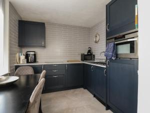 a kitchen with blue cabinets and a black counter top at 38 St Margarets in Dover +14 photos