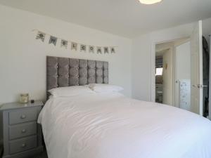 a bedroom with a white bed with a gray headboard at 38 St Margarets in Dover
