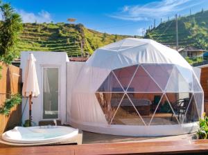 an igloo house with a tub on a deck at Hanara Private Glamping in Panjadakan