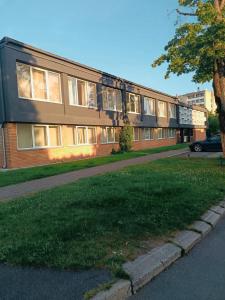 a building with a green lawn in front of it at Rannatee Rooms in Pärnu