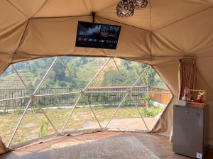 a view from inside a tent with a tv inside at Hanara Private Glamping in Panjadakan