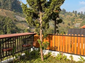 a balcony with a table and chairs and a tree at Hanara Private Glamping in Panjadakan +2 photos