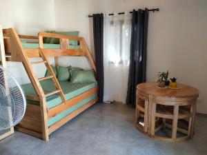 a room with a bunk bed and a table at Residence Meva Soa Majunga in Amborovy
