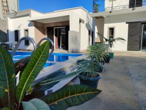 a swimming pool with plants in front of a building at Residence Meva Soa Majunga in Amborovy