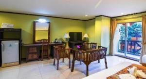 a living room with green walls and a table and chairs at Phuphaya Resort Pattaya in Pattaya South