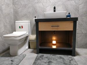 a bathroom with a sink and a toilet and a candle at Residence Meva Soa Majunga in Amborovy +9 photos