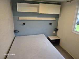 a small bedroom with a bed and a window at Chalet te huur op het 'Eiland' Camping de Kleine Wielen Leeuwarden in Leeuwarden