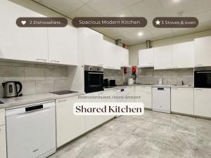 a white kitchen with white cabinets and appliances at Vibrant Raamsdonksveer, near Efteling & Biesbosch in Raamsdonksveer