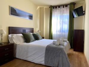 a bedroom with a large white bed and a window at R2R - El Rincón de Luiña - 310A in Soto de Luiña