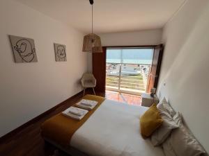 a bedroom with a bed and a large window at Onda Beach House in Cortegaça +17 photos