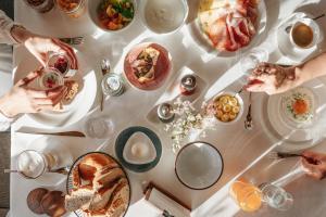 ein weißer Tisch mit Tellern voller Essen darauf in der Unterkunft Panorama Hotel Flora in Villanders + 25 Fotos