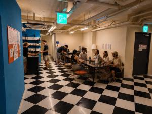 a group of people sitting at tables in a room at Bluedot Poshtel in Seoul