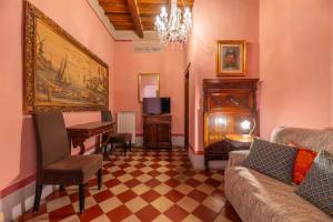 a living room with a table and a couch and a piano at Due Borghi Guest House in Pisa