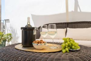 a table with two glasses of wine and a bowl of grapes at Biccari 6 Terrace Apartament in Lecce