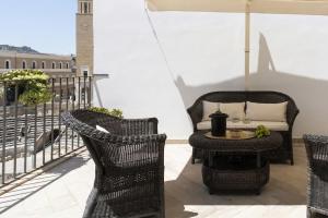a balcony with chairs and a table and an umbrella at Biccari 6 Terrace Apartament in Lecce