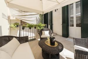 a patio with wicker chairs and a table and an umbrella at Biccari 6 Terrace Apartament in Lecce