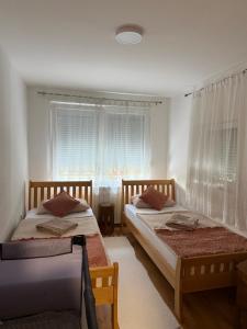 two beds in a room with a window at Villa Medina in Sarajevo